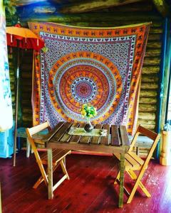 奥索里乌Pousada Ananda的挂地毯的墙上的桌椅