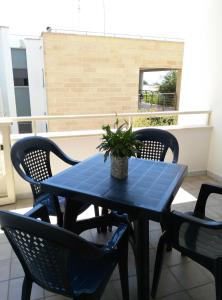 萨尔维Salento Mare Sabbioso的阳台上摆放着蓝色的桌椅和盆栽植物