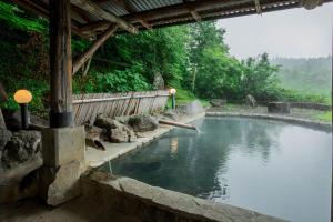南小国町奥吉昂斯恩奥吉索日式旅馆的一座带围栏和树木的大型水池