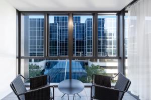 悉尼巴拉玛打斯凯套房酒店的窗户间里的玻璃桌和椅子