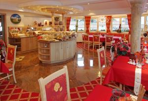 格英Pension Sunnberg的一间带红色桌椅的餐厅和一间厨房