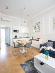 萨格勒布White Rose Apartment的客厅以及带桌子和沙发的厨房。