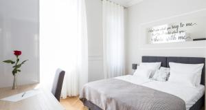 萨格勒布White Rose Apartment的白色卧室配有床和桌子
