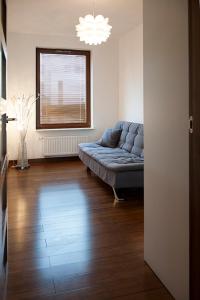 华沙莫克托夫多莫特尔公寓的客厅设有蓝色的沙发和窗户。