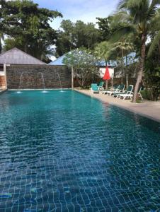 拉迈海湾别墅酒店的一个带椅子和墙壁的大型蓝色游泳池