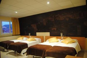 莫尼斯特罗尔Guilleumes Montserrat的墙上画画的房间的三张床