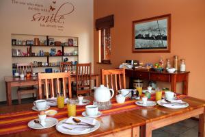 莫塞尔湾Avenues Guesthouse的用餐室配有木桌和食物