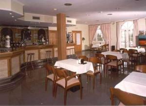 圣地亚哥－德孔波斯特拉圣维森特酒店的一间带桌椅的餐厅和一间酒吧