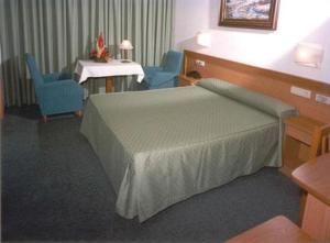 圣地亚哥－德孔波斯特拉圣维森特酒店的客房设有床、两把椅子和水槽