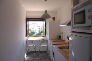 隆达布埃纳维斯塔公寓的一个带桌子和两张凳子的小厨房