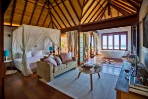 MiramarSentidos Beach Retreat的客厅配有床、沙发和浴缸