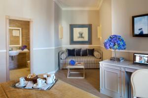 那不勒斯特米努斯星际酒店的客厅配有沙发和桌子