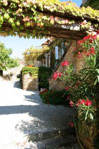 Saint-Amand-de-ColyLa vignolle的鲜花盛开的花园,砖砌建筑