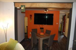 雷杜Lesse matinal的一间拥有橙色墙壁和桌椅的用餐室