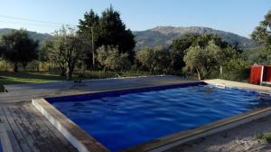 马尔旺Quinta Do Vaqueirinho - Agro-Turismo的一个带木甲板和蓝色海水的游泳池