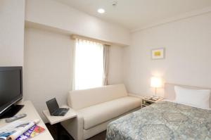 陆奥市尤尼塞特木慈酒店的酒店客房设有沙发、床和电视。