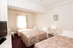 陆奥市尤尼塞特木慈酒店的酒店客房设有两张床和一台平面电视。