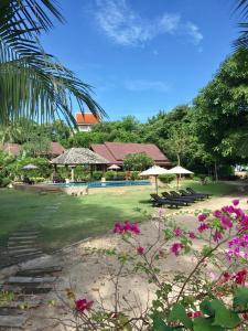湄南海滩班拉加河内别墅酒店的一个带游泳池和一些粉红色花卉的度假胜地