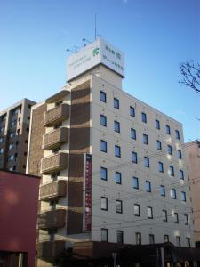 苫小牧市Hotel Tomakomai Green Hills的白色的建筑,上面有标志