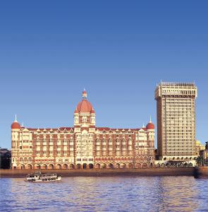 孟买孟买泰姬马哈拉宫殿酒店的河上一座大建筑,水中有一条船