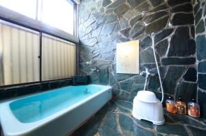 日光福富士日式旅馆的一间石墙内带浴缸的浴室