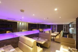 钦奈Hotel SRR Grand的餐厅内带紫色照明的用餐室