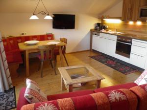 罗伊特Alpenhof Wängle的带沙发和桌子的客厅以及厨房。
