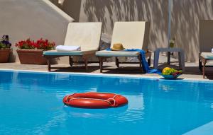 卡马利马里奥一室公寓酒店的游泳池里红色的木筏,带椅子