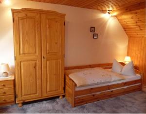 魏玛Pension a la Kleinert的一间卧室配有一张床和一个木制橱柜