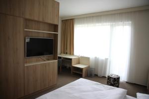 赫任斯科Hotel Devítka的酒店客房配有一张床、一台电视和一张书桌。