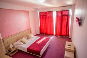 艾福雷诺德Hotel Vis的一间小卧室,配有床和红色窗帘