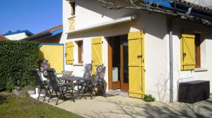 波讷地区圣朱利安Park Village Océlandes的一座带黄色门和桌椅的房子