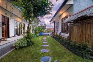 坎古巴厘岛满月旅馆的两栋建筑之间草地上岩石的花园