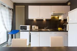 曼德琉-拉纳普勒Rana's flat的厨房配有白色橱柜和蓝色椅子