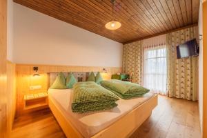 布拉伊埃斯莫赛火富博哥斯特奥斯农家乐的一间卧室配有两张带绿色枕头的床