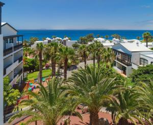 普拉亚布兰卡H10鲁比肯皇宫酒店的享有棕榈树和海洋度假村的空中景致