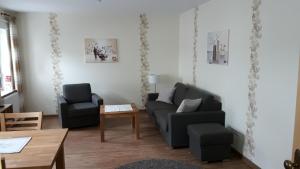 维林根维林镇中心假日公寓的客厅配有沙发、两把椅子和一张桌子