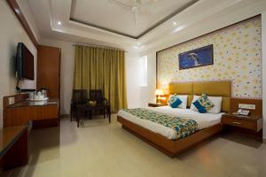 新德里Hotel Krishna Deluxe-By RCG Hotels的酒店客房,配有床和电视