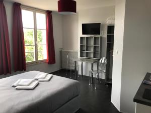 特鲁瓦SmartAppart Troyes的一间卧室配有一张床、一张书桌和一个窗户。