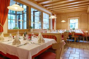 雷西亚Hotel Schwarzer Adler的用餐室设有桌椅和窗户。