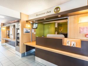 盖斯波尔塞姆B&B HOTEL Strasbourg Sud Geispolsheim的墙上有标牌的快餐店