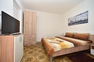 布德瓦MG apartments and rooms的一间卧室配有一张床和一台平面电视