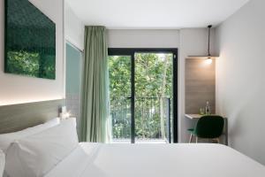 巴塞罗那纽巴塞罗那酒店的一间卧室设有一张床和一个大窗户
