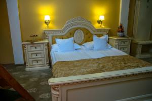 萨图马雷阿斯托利亚酒店的一间卧室设有一张大床和两个床头柜