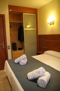 巴塞罗那Apartaments Aragó565的酒店客房 - 带两张床和床上的毛巾