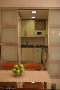 巴塞罗那Apartaments Aragó565的厨房里放着一碗苹果放在桌子上