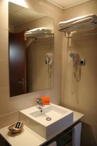 巴塞罗那Apartaments Aragó565的一间带水槽和镜子的浴室