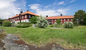 韦姆德范戈比洛斯酒店的一座红色和白色的大建筑,有草地庭院
