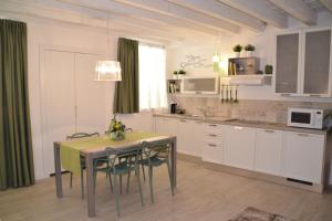 维罗纳Verona White Lodge的一间带桌椅的厨房和一间带白色橱柜的厨房