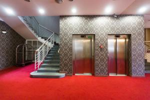 纳霍德纳霍德乌贝兰卡酒店的两部电梯,位于一栋铺有红地毯的建筑内